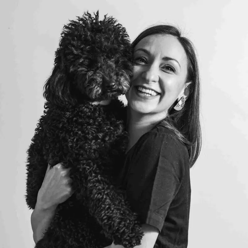 Doktorka veterine Jovana Božić drži psa u naručju i osmehuje se.